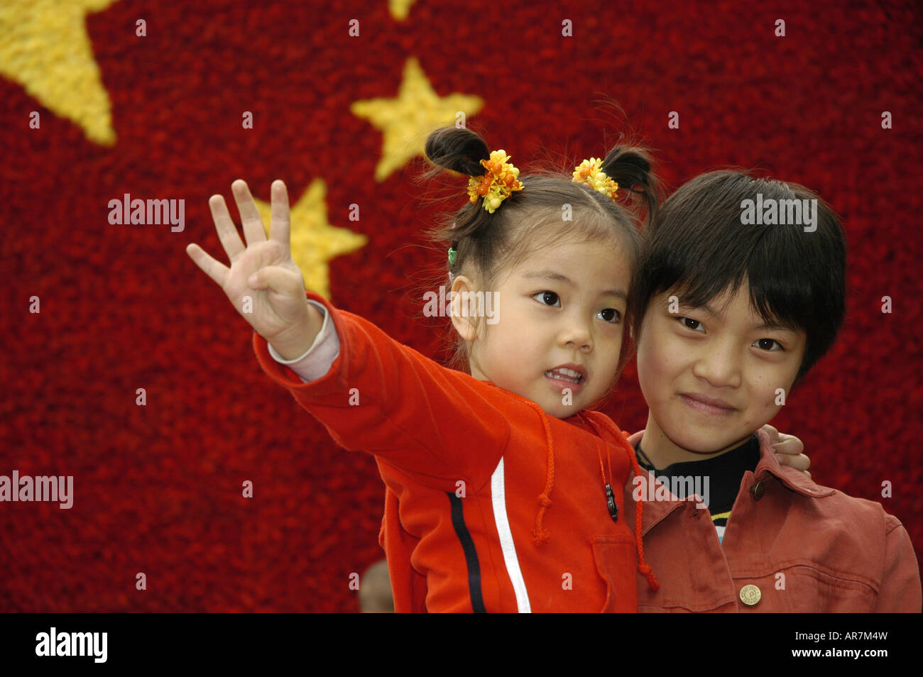 Kinder vor einer chinesischen Nationalflagge aus Blumen zum Gedenken an nationalen Tag Chongqing China gemacht Stockfoto