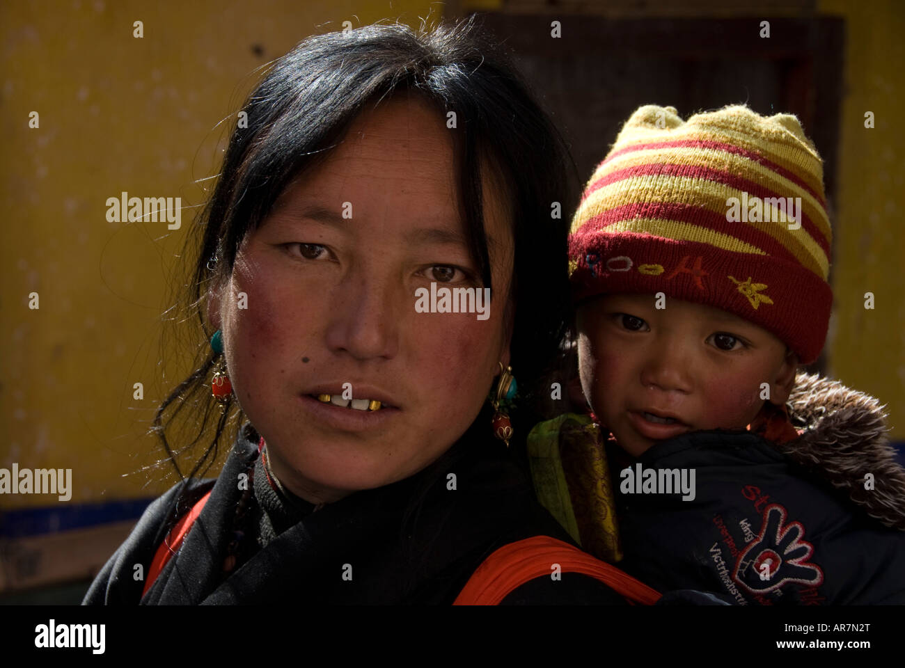 Eine horizontale Foto des tibetischen Dame Pilger hält ihr Baby auf den Stufen des Potala Palast New Years Day, Lhasa, Tibet, China. Stockfoto