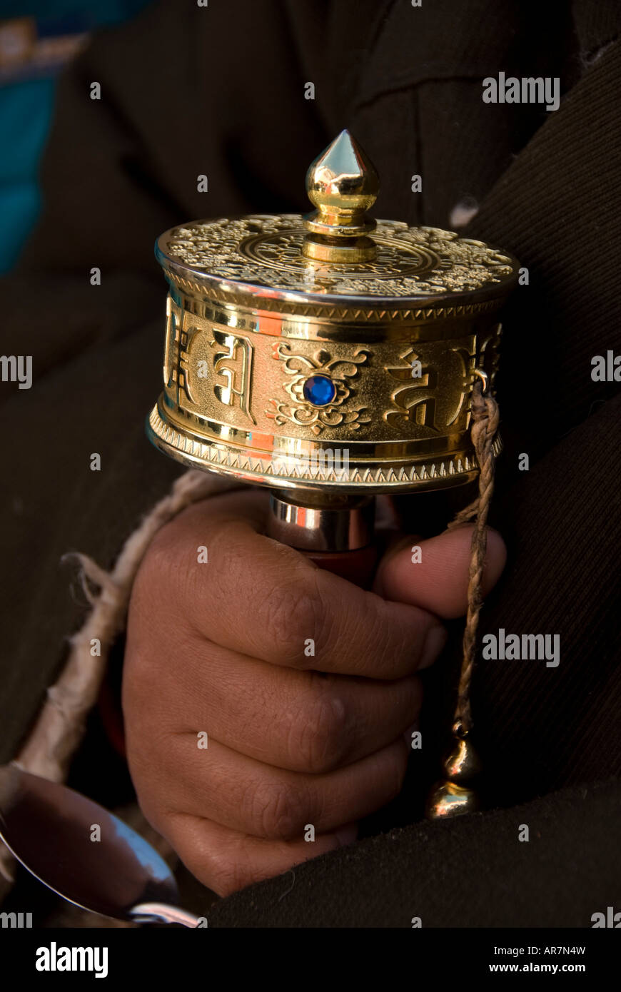 Nahaufnahme von eine Mani Gebetsmühle im Besitz einer älteren Frau Pilger Eingabe der Potala-Palast auf tibetische Neujahr Stockfoto