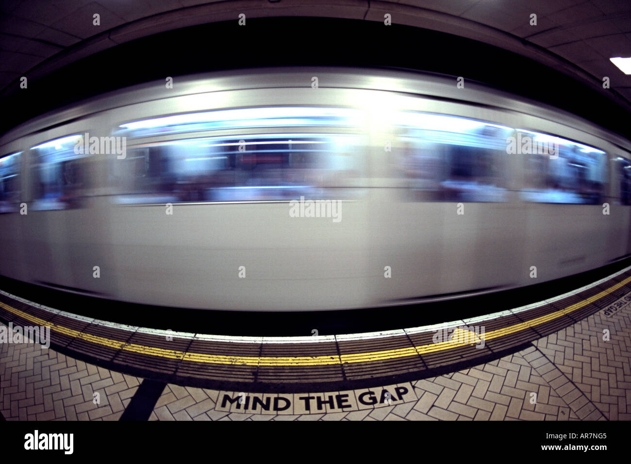 District Line u-Bahn vorbei an einer Plattform in London. Fotografiert mit einem Fisheye-Objektiv. Stockfoto