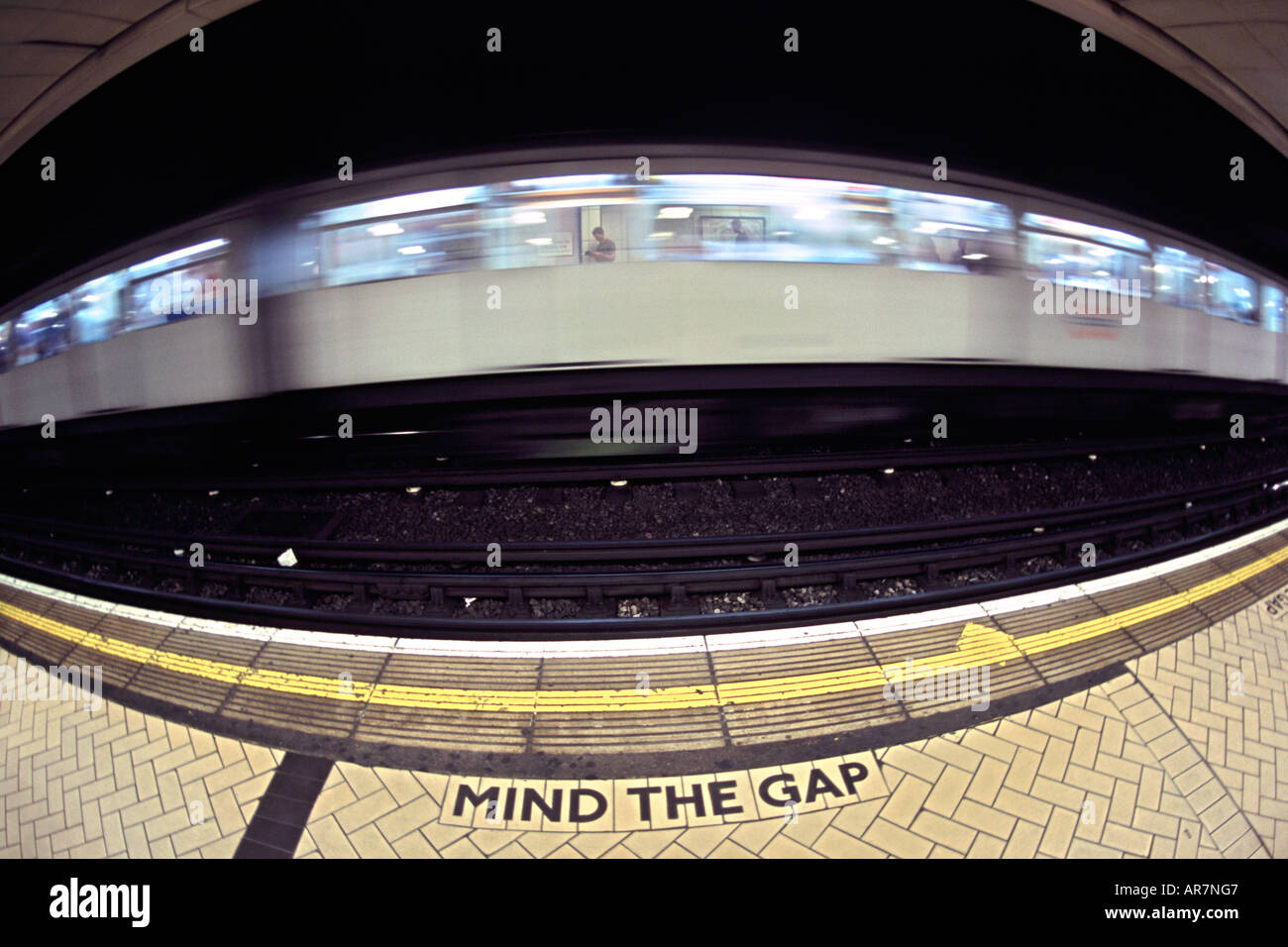 District Line u-Bahn vorbei an einer Plattform in London. Fotografiert mit einem Fisheye-Objektiv. Stockfoto