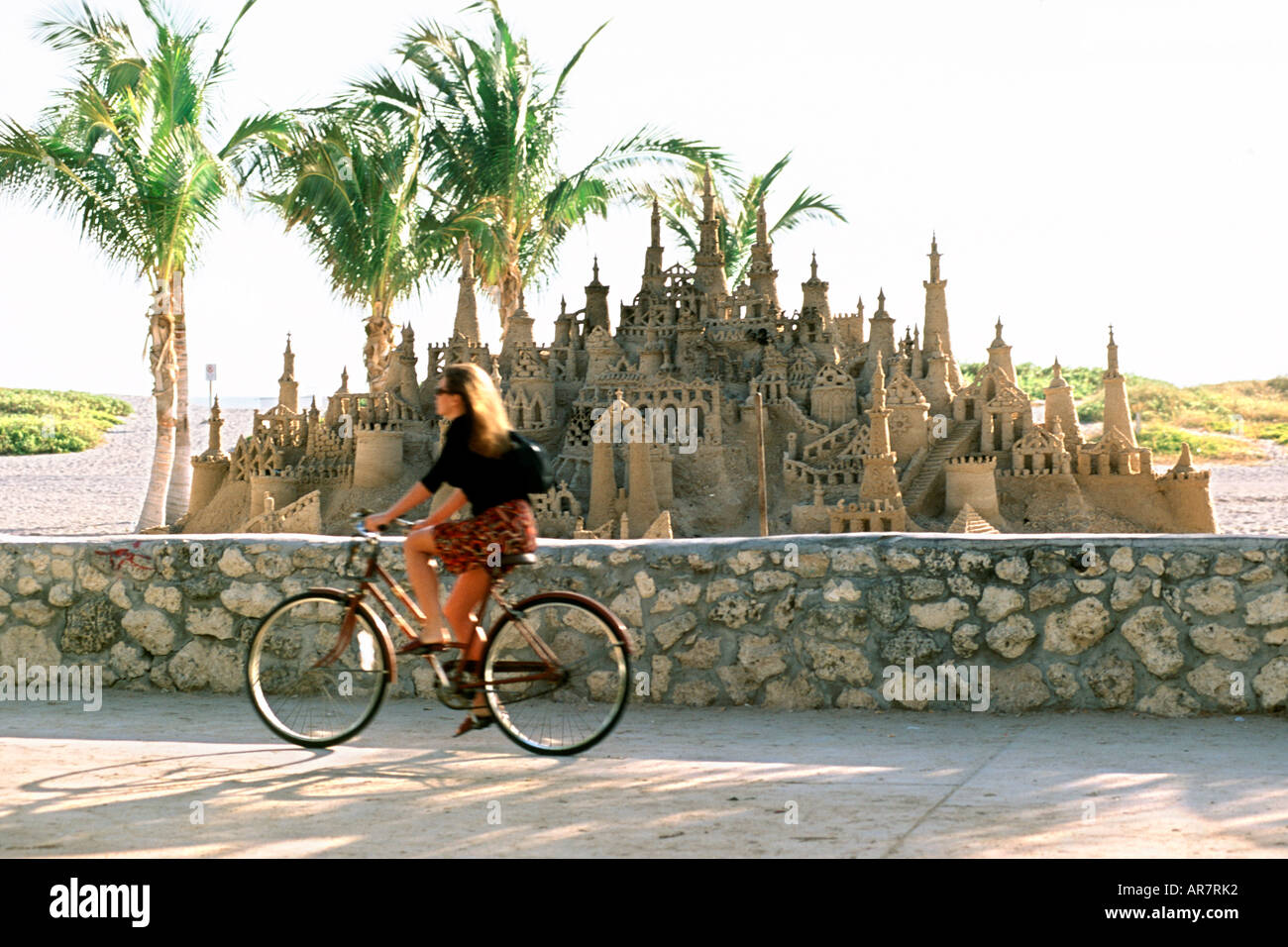 Ein Radfahrer fährt vorbei an einem riesigen Sandburg in Miami Beach Florida. Stockfoto
