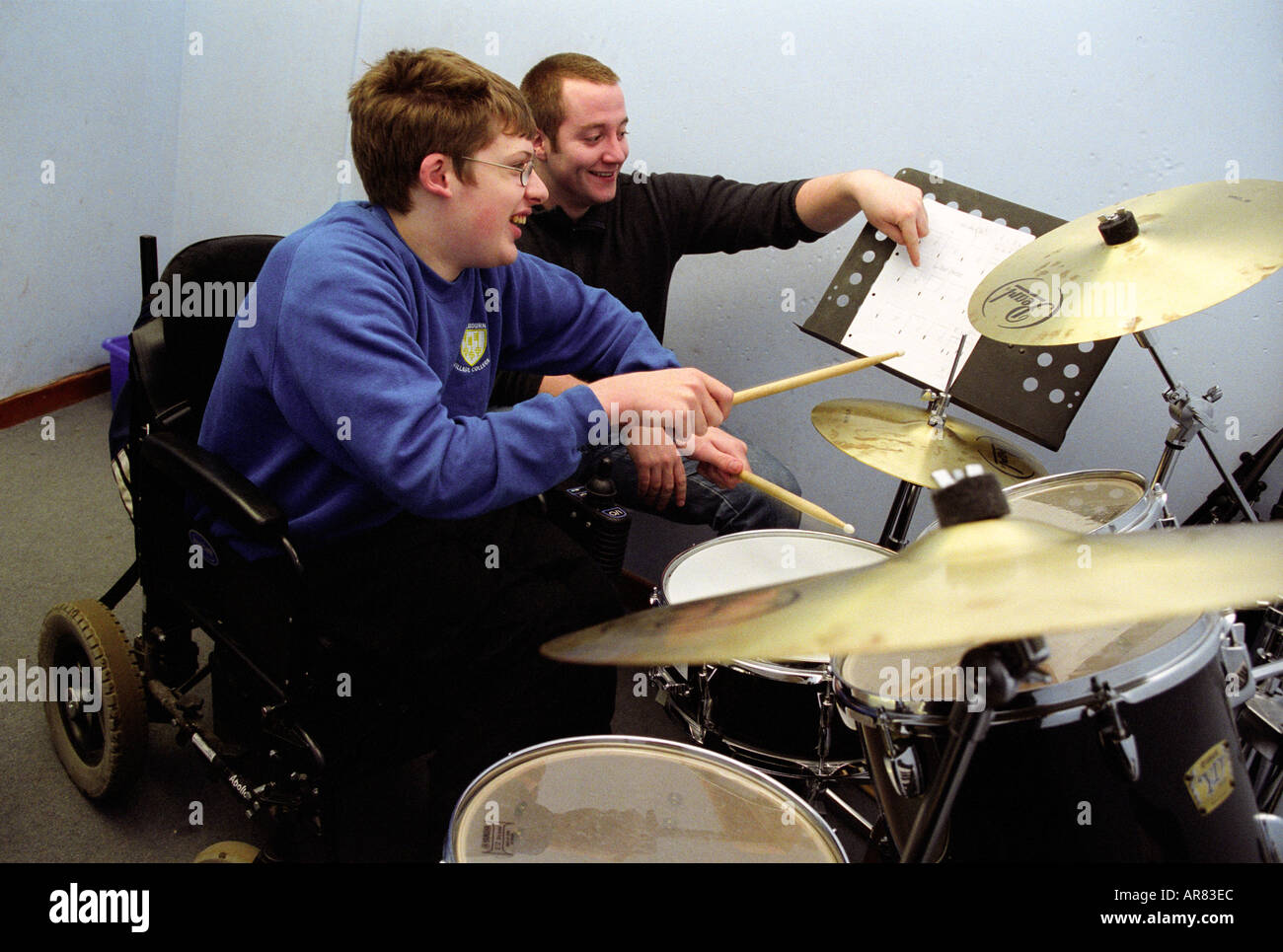 Behinderten Schüler mit Tutor spielen Schlagzeug-Mittelschule Stockfoto