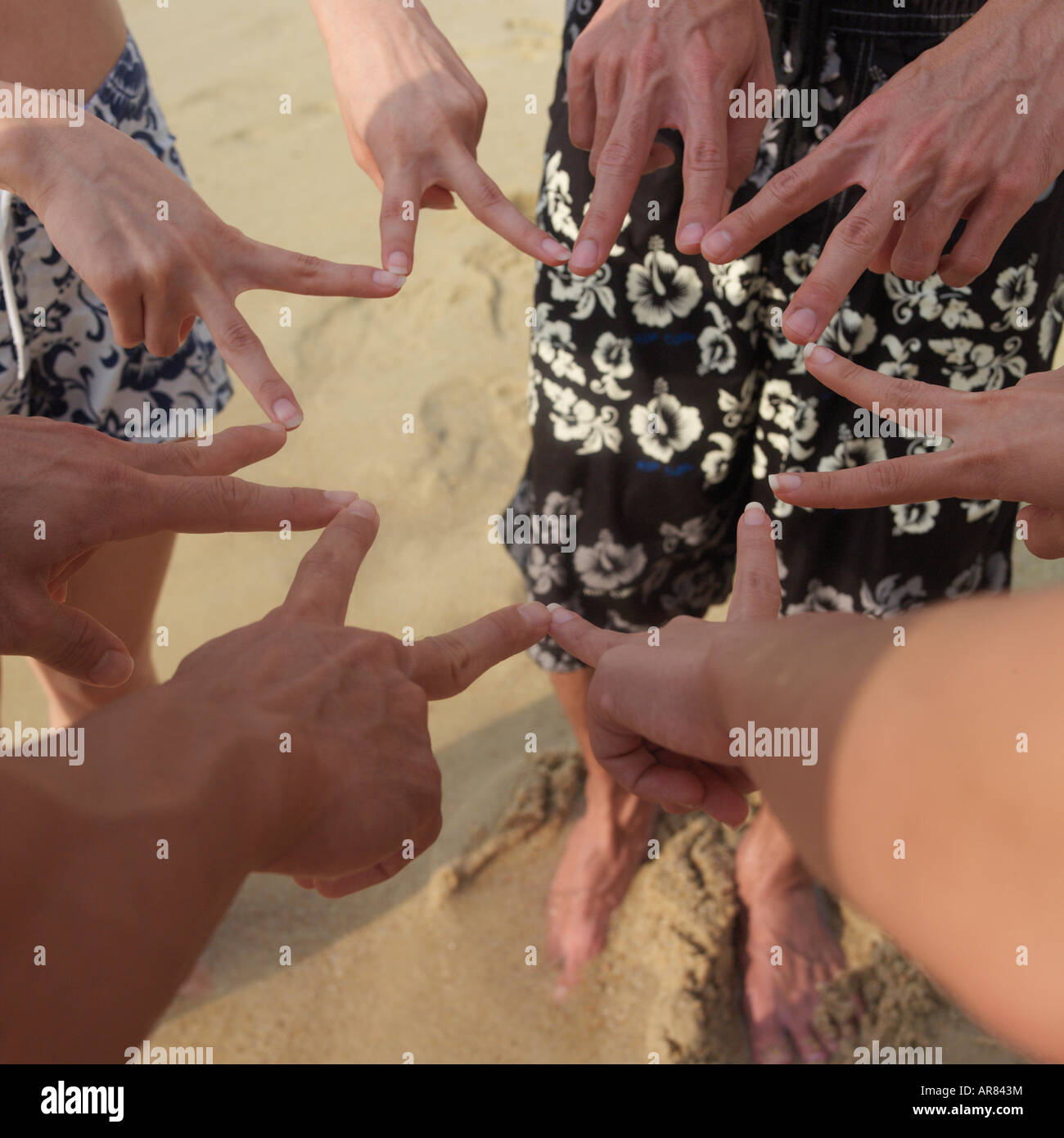 Nahaufnahme von vier Paar Hände am Strand Stockfoto