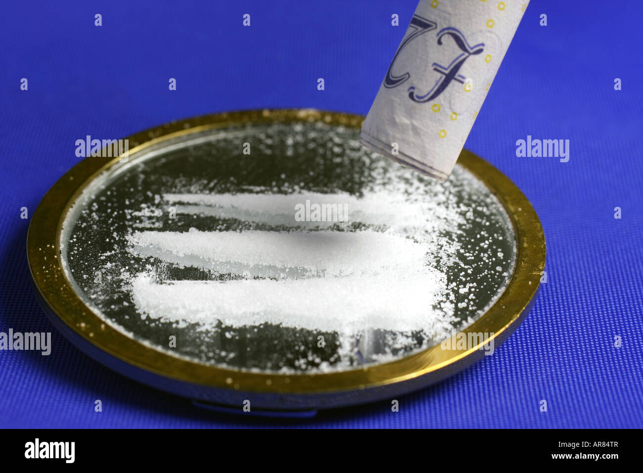 Schnupfen von Kokain aus einem Spiegel durch einen aufgerollten 20-Pfund-note Stockfoto