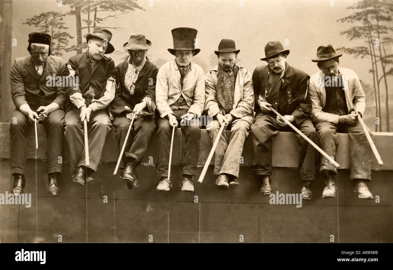 Vintage Gruppenbild der Männer sitzen auf Zaun Hüte tragen Stockfoto