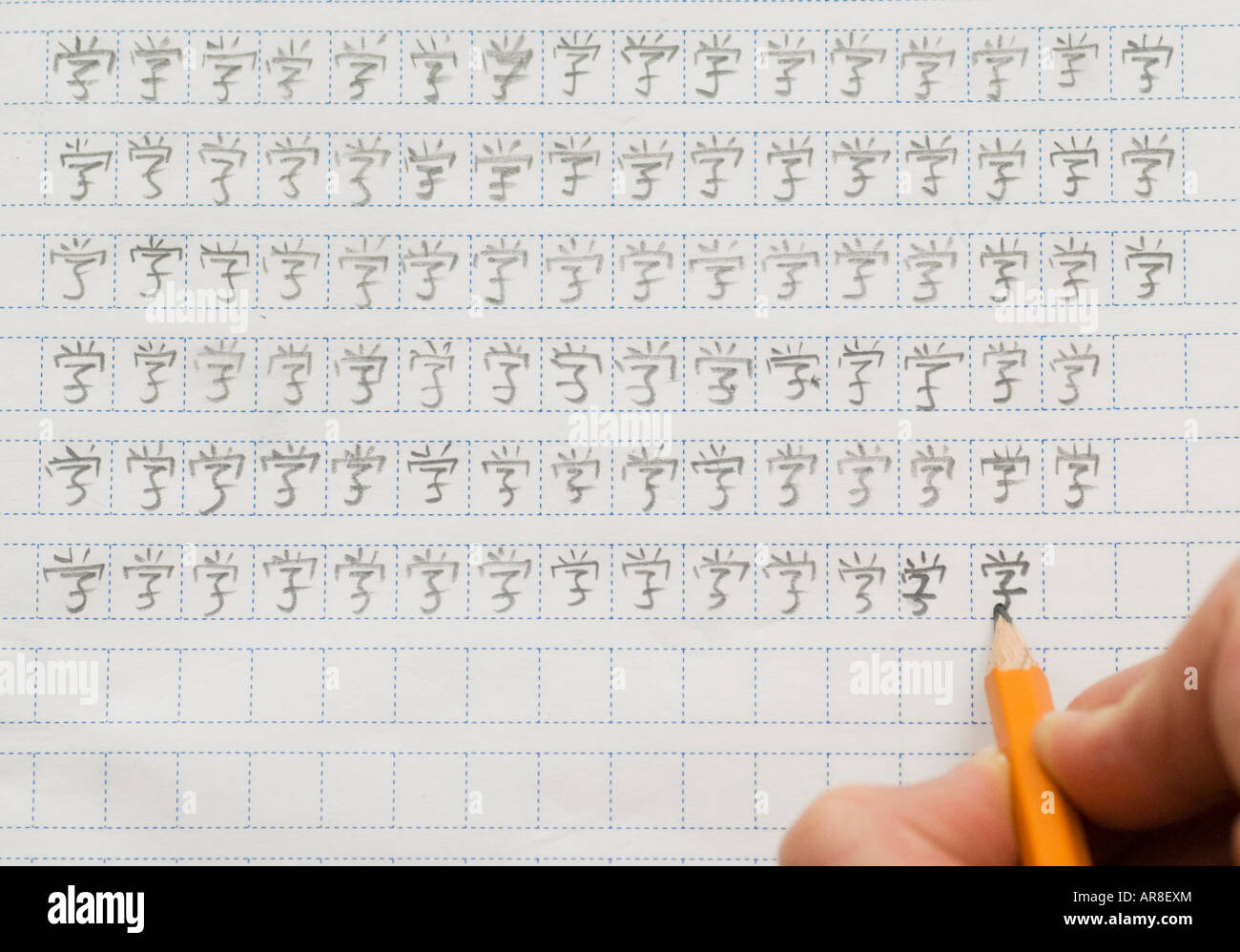 Ausländischer Student chinesische Schriftzeichen durch Wiederholung mit  Bleistift und Karopapier schreiben lernen Stockfotografie - Alamy