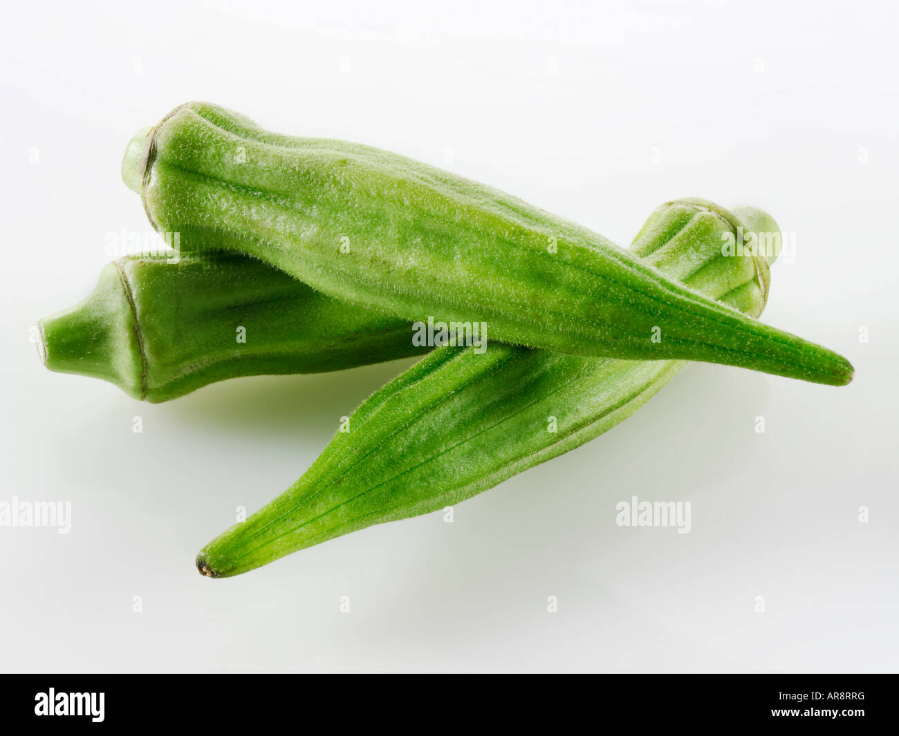 Frisch Ocker-, Bhindi oder Damen Finger ganz und ungekocht vor einem weißen Hintergrund für Ausschneiden Stockfoto