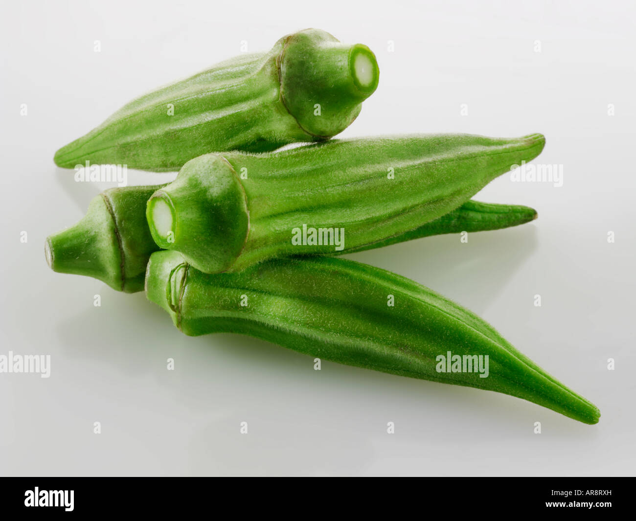 Frisch Ocker-, Bhindi oder Damen Finger ganz und ungekocht vor einem weißen Hintergrund für Ausschneiden Stockfoto