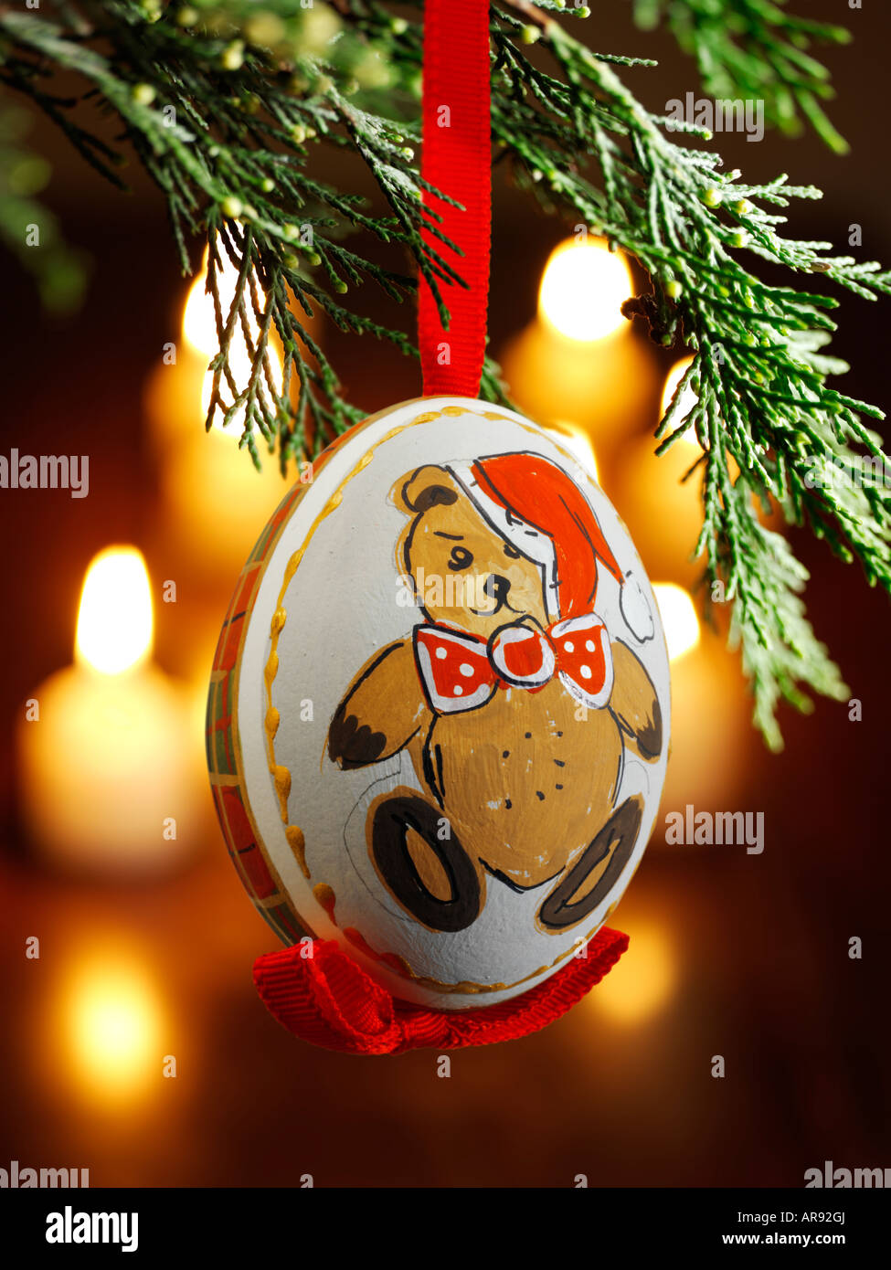 Traditionelle festlich geschmückte Weihnachtskugel, die an einem Weihnachtsbaum hängt Mit Licht dahinter Stockfoto