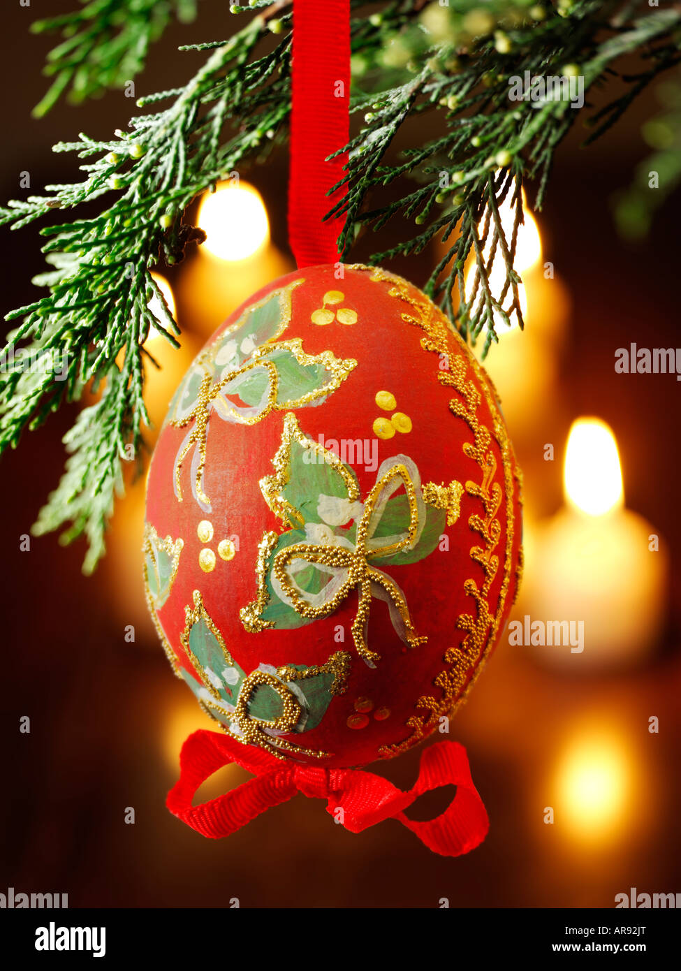 Traditionelle festlich geschmückte Weihnachtskugel, die an einem Weihnachtsbaum hängt Mit Licht dahinter Stockfoto