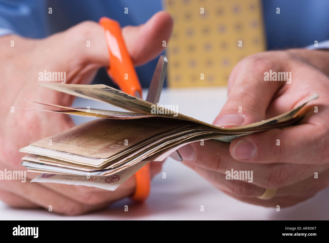 Schuss der Geschäftsmann hält Geld zerschneiden Banknoten mit einer Schere hautnah Stockfoto