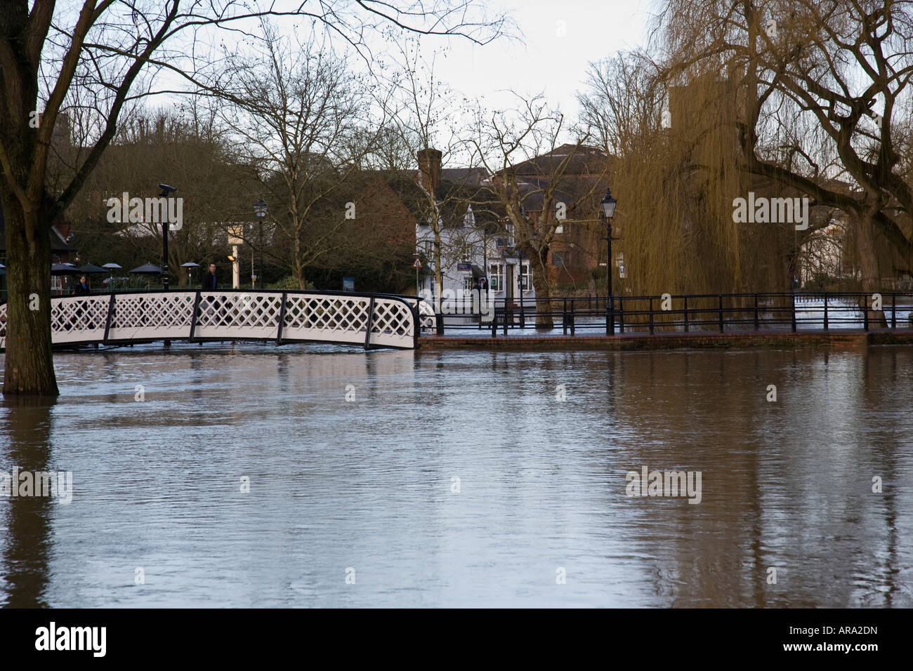 Menschen, die über eine Brücke über die überfluteten Fluss Wey in Guildford, Surrey, England. Stockfoto