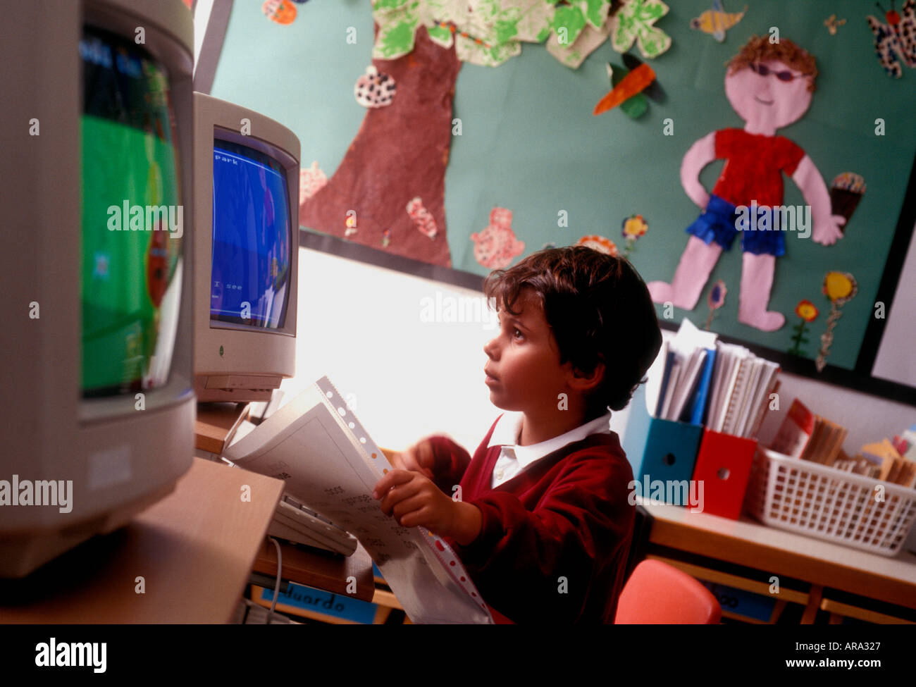 Computer-Bildschirm der 1990er Jahre Kleinkind Schuljunge im Alter von 3 bis 5 Jahren auf dem Computer-Bildschirm mit Kunstwerken im Hintergrund frühen Kleinkind Computerunterricht in den 1990er Jahren Stockfoto