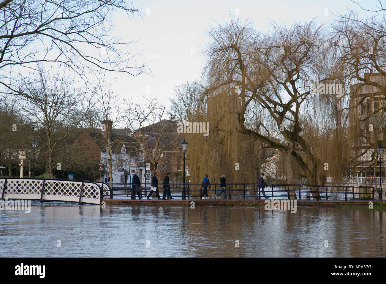 Eine Gruppe von Menschen machen ihren Weg entlang eines Weges über die überfluteten Fluss Wey in Guildford, Surrey, England. Stockfoto