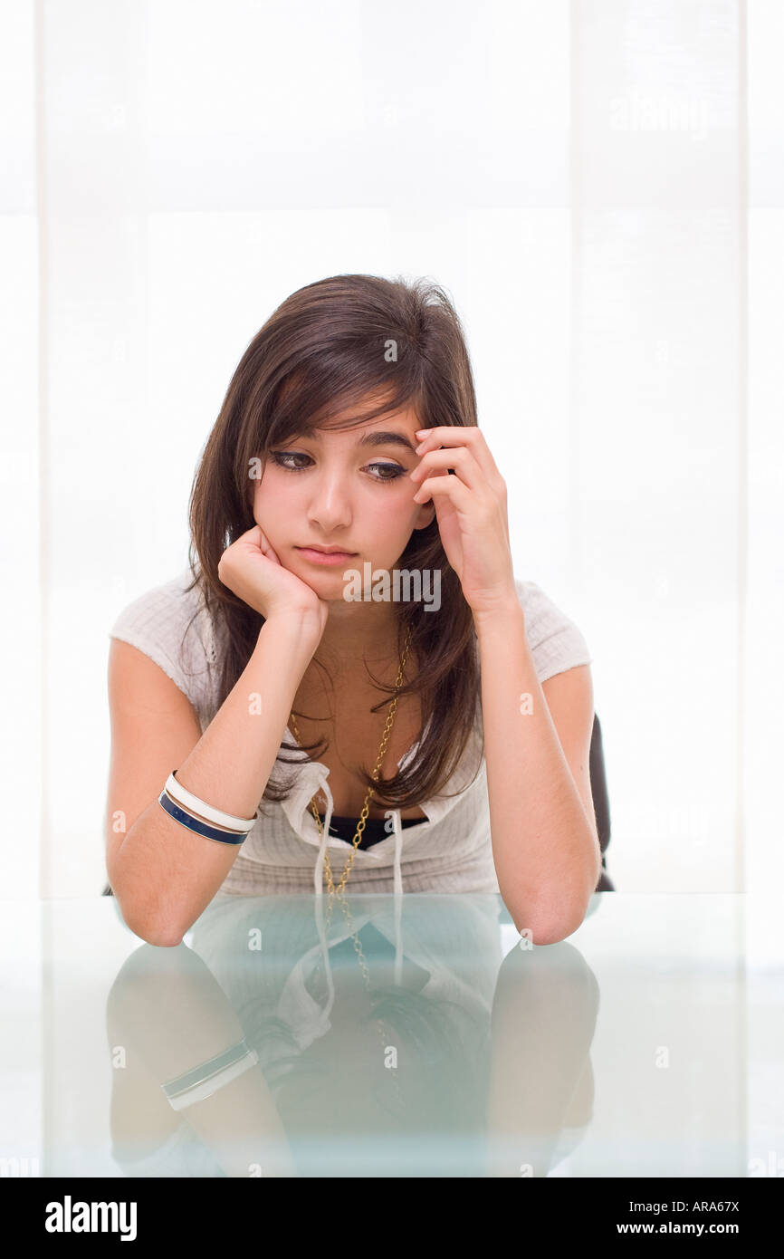 Teenager-Mädchen am Tisch sitzen und schauen traurig Stockfoto