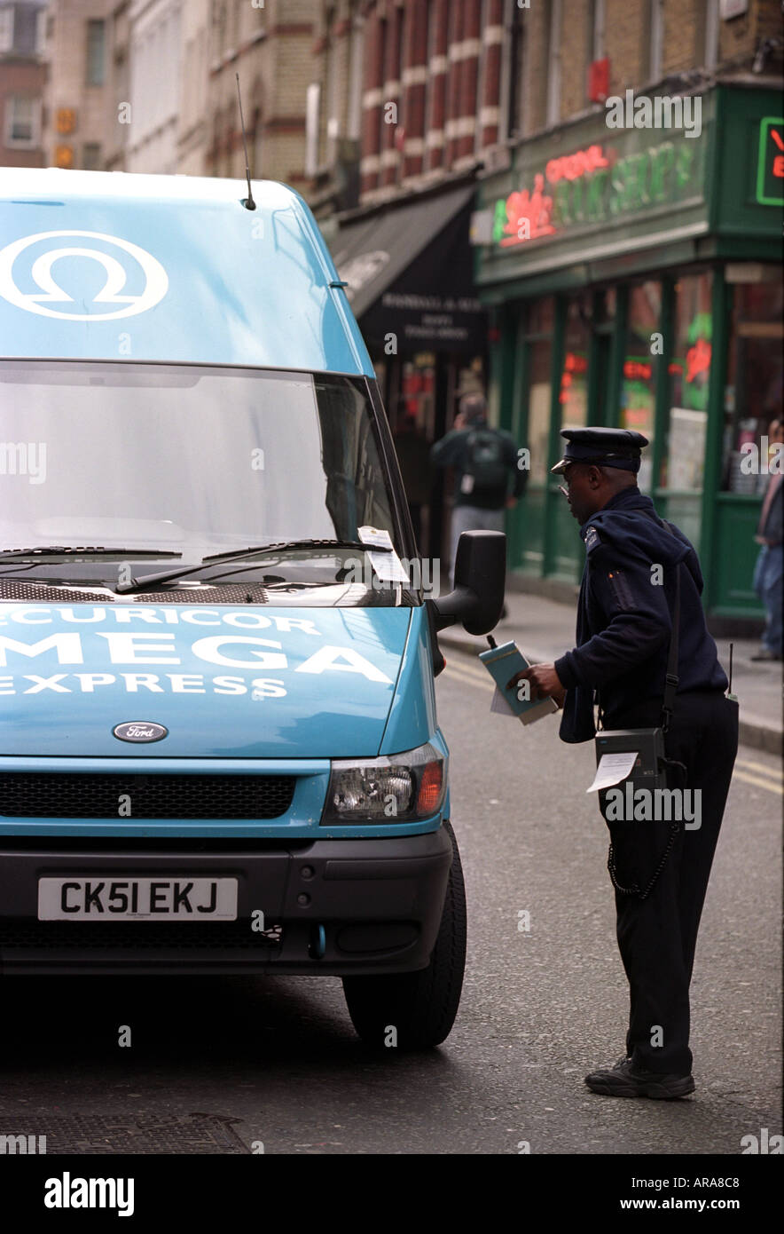 Ein Parkplatz-Wächter stellt ein Ticket zu einem Lieferwagen in Soho London England UK Stockfoto
