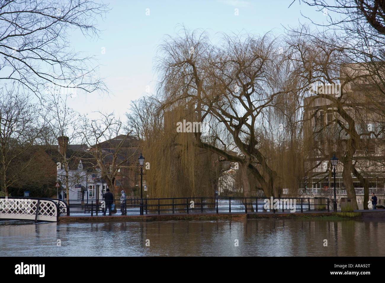Ein paar Anzeigen und die Fluten über eine Brücke über die überfluteten Fluss Wey in Guildford, Surrey, England. Stockfoto