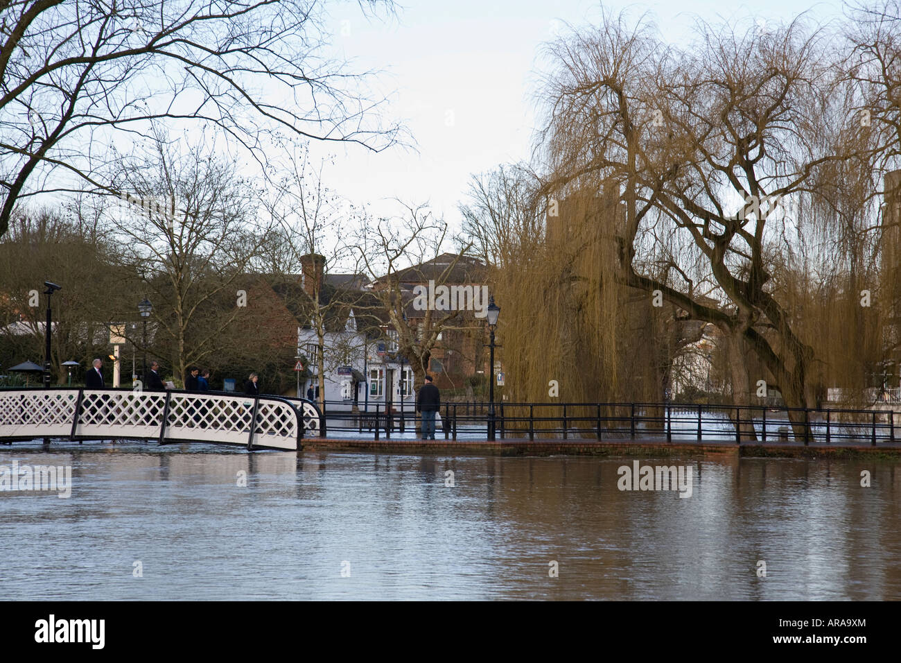 Eine Gruppe von Menschen eine Brücke überqueren die überfluteten Fluss Wey in Guildford, Surrey, England. Stockfoto