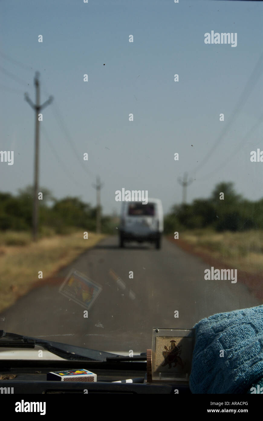 Der Blick aus dem Inneren des ein Nutzfahrzeug ein anderes Fahrzeug im Anschluss an eine gerade schmale Straße Madhya Pradesh Stockfoto