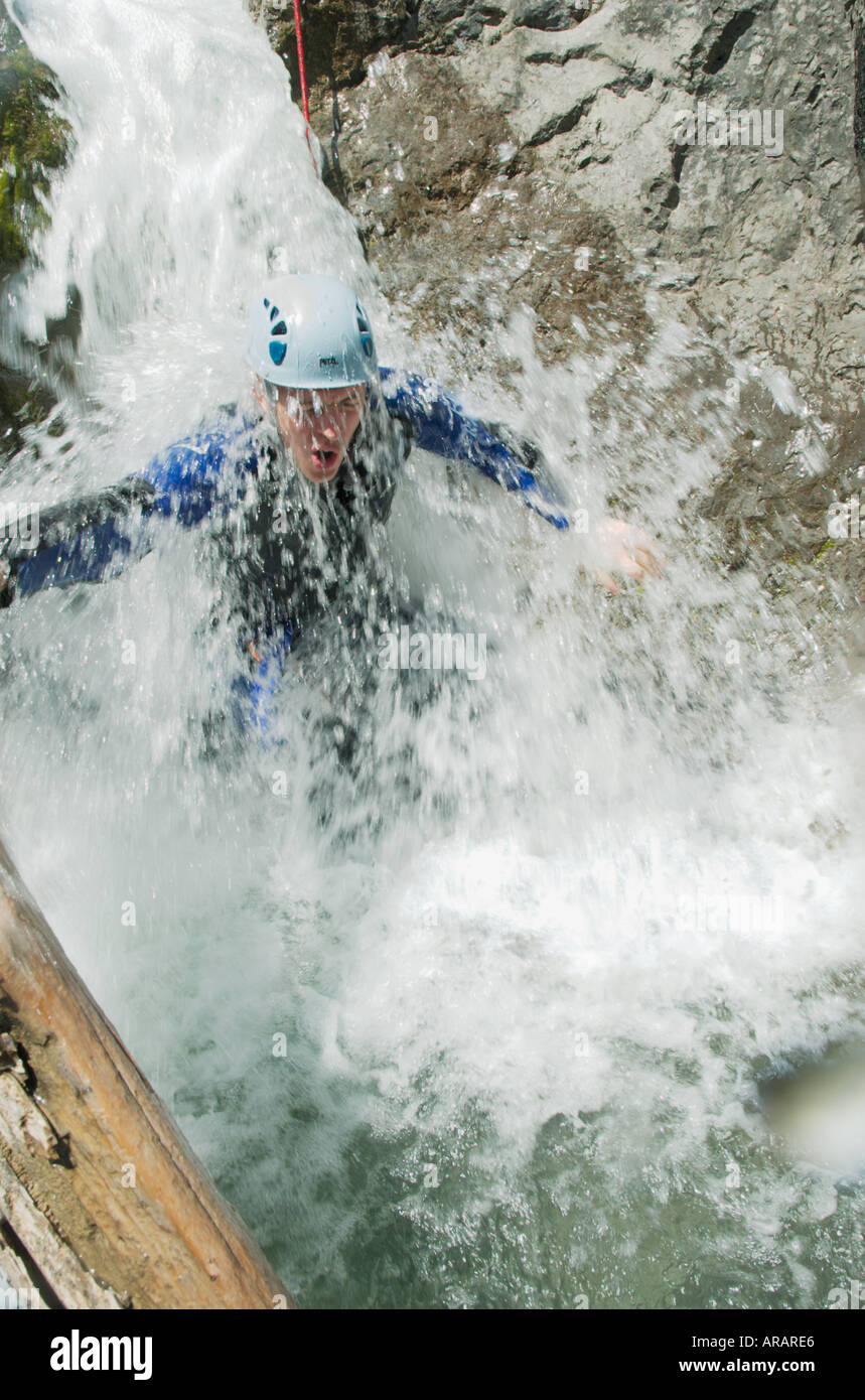 Mann bekommt ein Einweichen während einer Canyoning Expedition in eine Schlucht über das Lechtal Lechtal Tirol Österreich Stockfoto