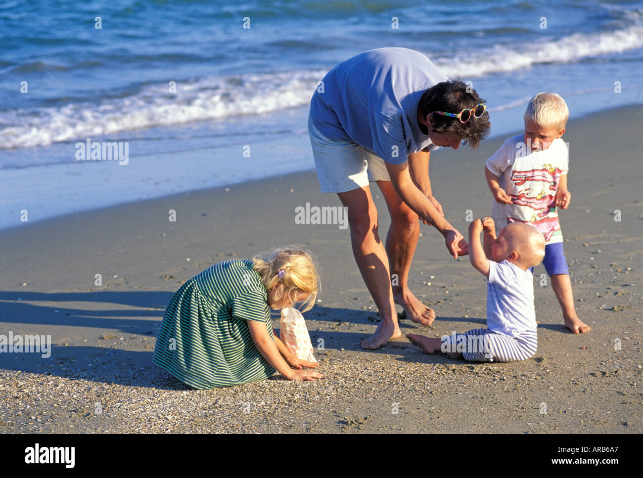 Mutter mit Kindern sammelt Muscheln am Strand Herr Stockfoto