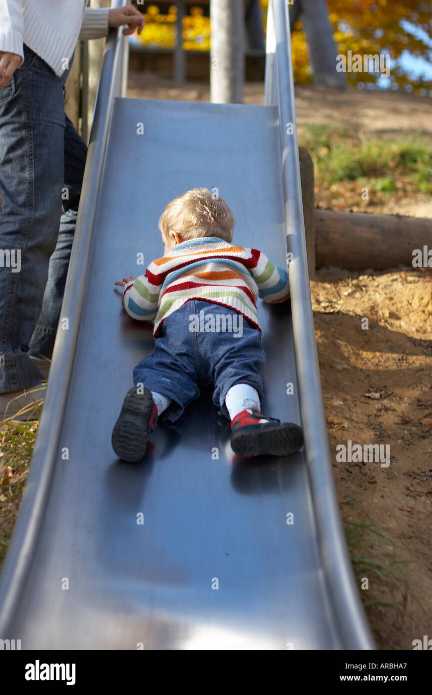 Baby rutscht die Rutsche auf dem Spielplatz Stockfoto