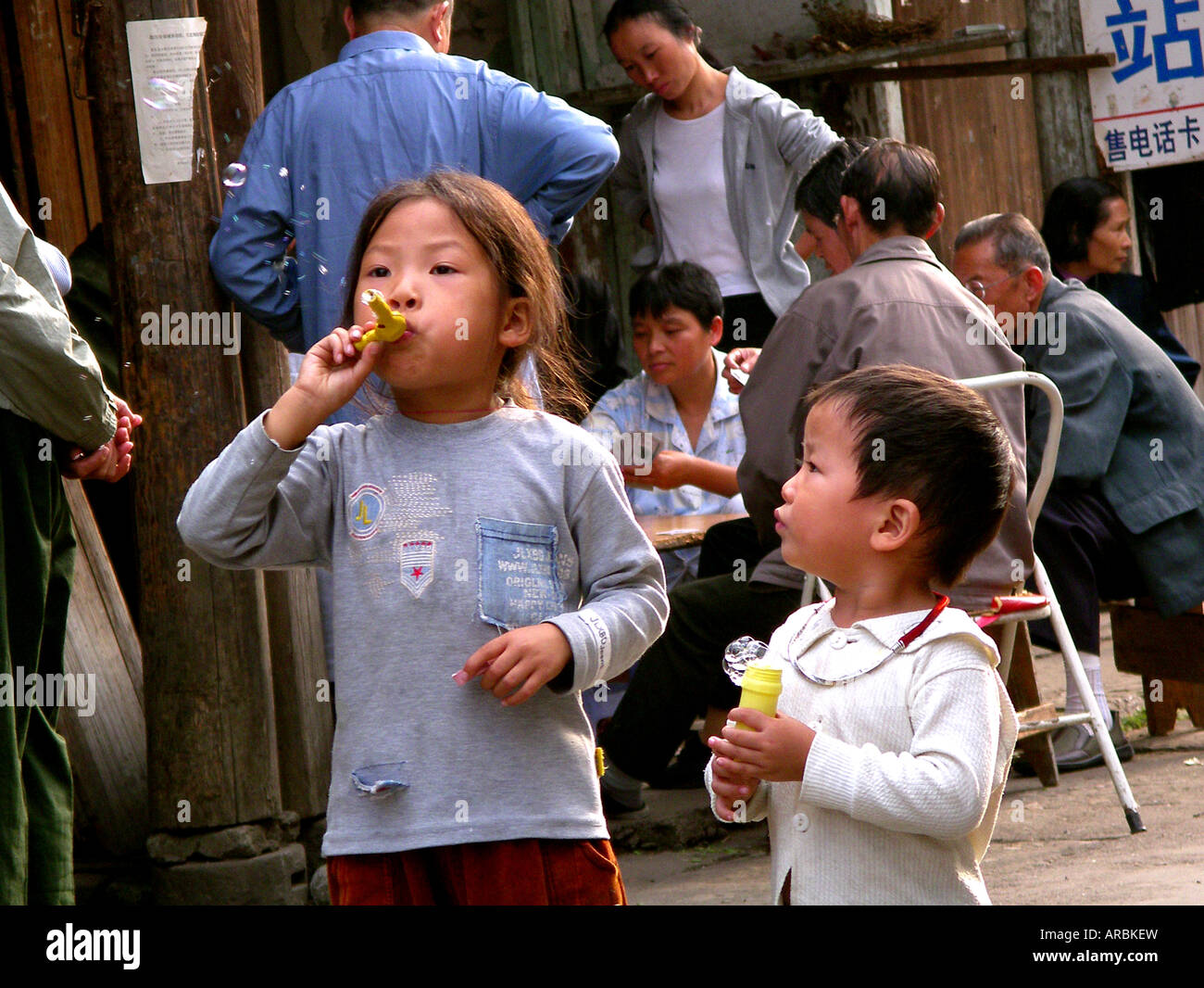 Junge chinesische Kinder Seifenblasen in einer hinteren Gasse. Stockfoto