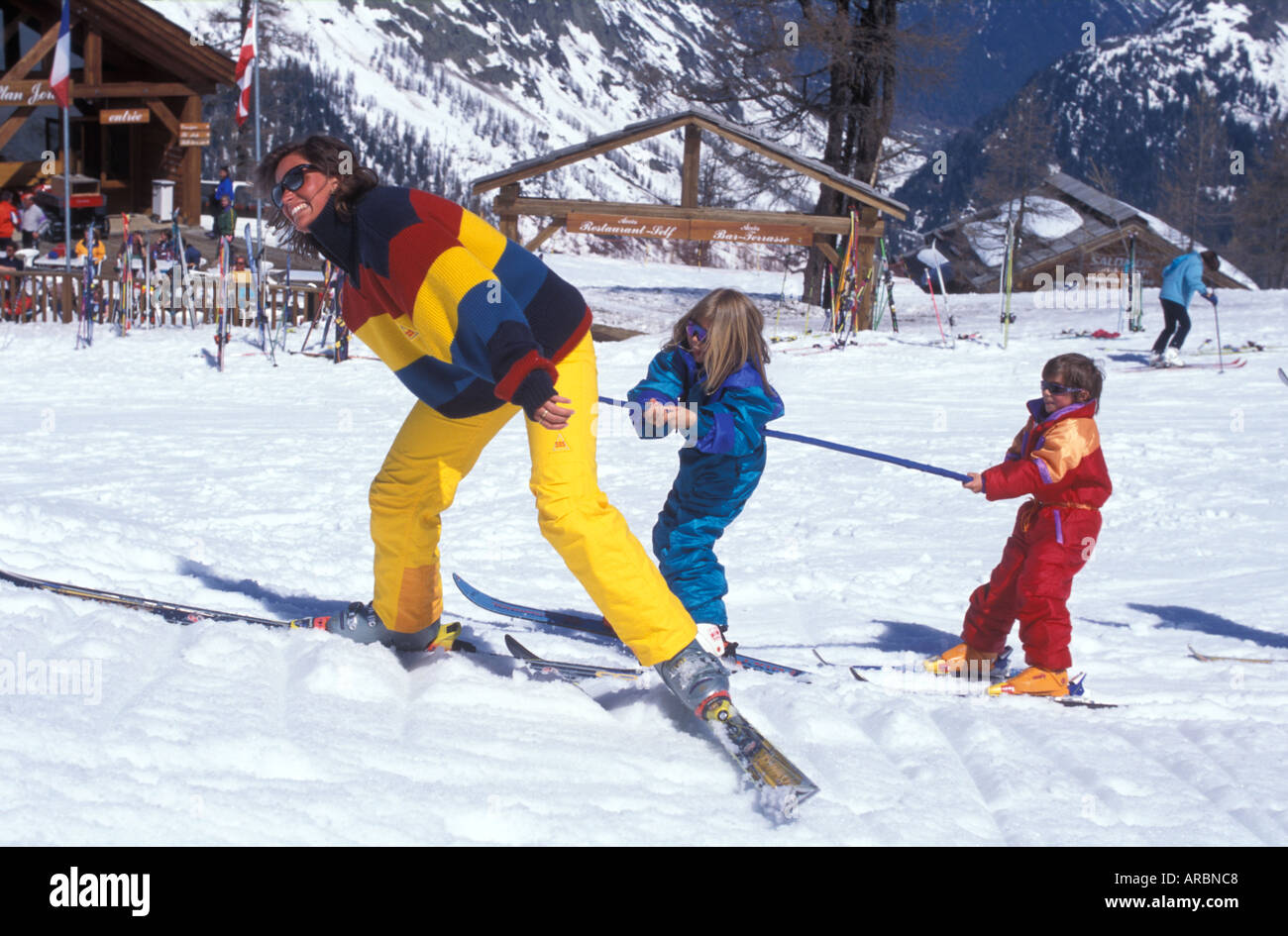 Mutter und zwei Kinder auf dem Kindergarten-Ski Pisten Stockfoto