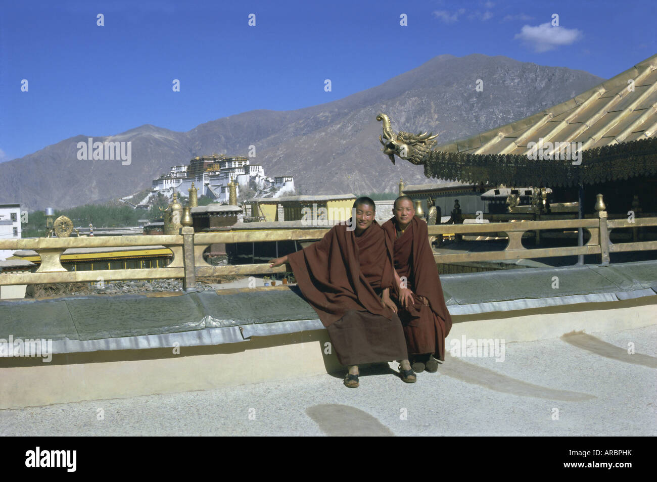 Zwei tibetische buddhistische Mönche im Jokhang-Tempel, der Potala-Palast hinter, Lhasa, Tibet, China, Asien Stockfoto
