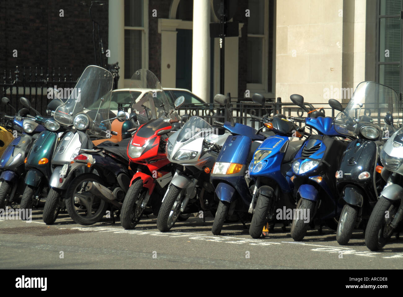 London St James Square parkte Motorräder und Motorroller auf einem zugewiesenen Parkplatz vor den Büros in England Großbritannien Stockfoto