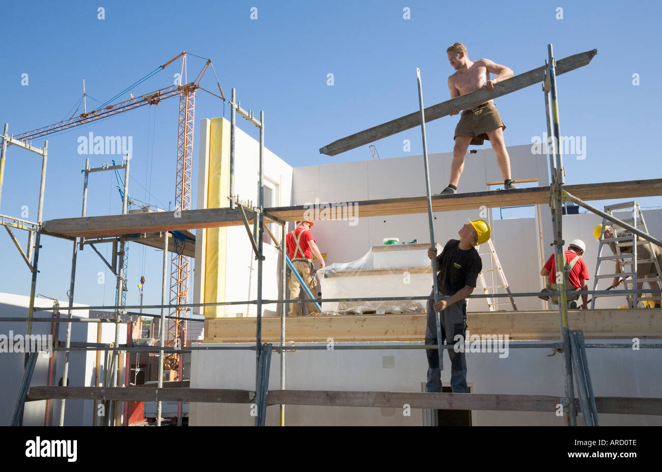 Gerüstbauer bei der Arbeit auf einer Fertighaus-Baustelle Stockfoto