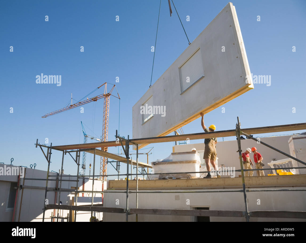 Bauarbeiter bauen ein Fertighaus in einem neuen Wohngebiet Stockfoto