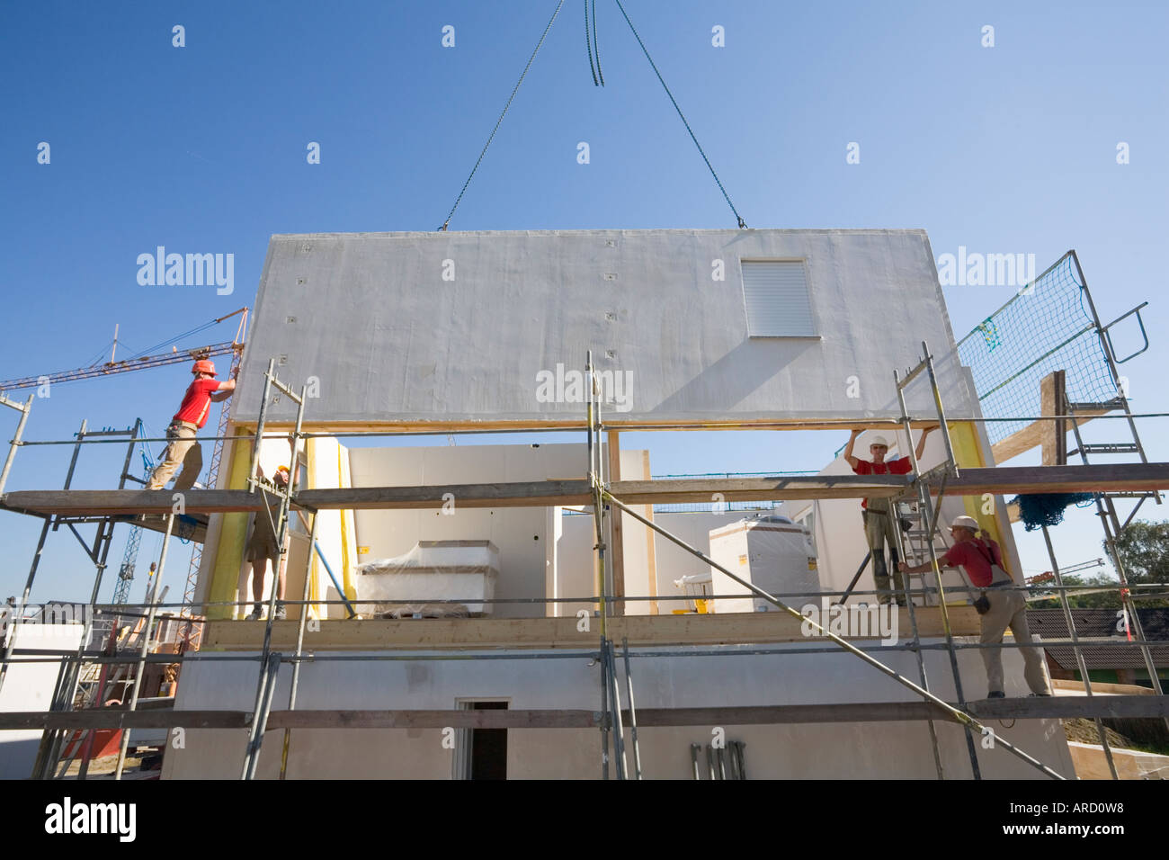 Bauarbeiter bauen ein Fertighaus in einem neuen Wohngebiet Stockfoto
