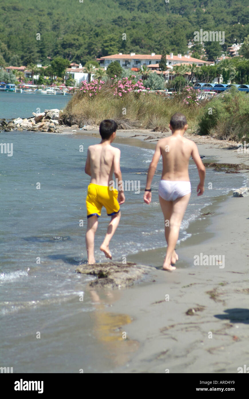 Jungs, die am Strand von Akyaka Turkey spazieren Stockfoto