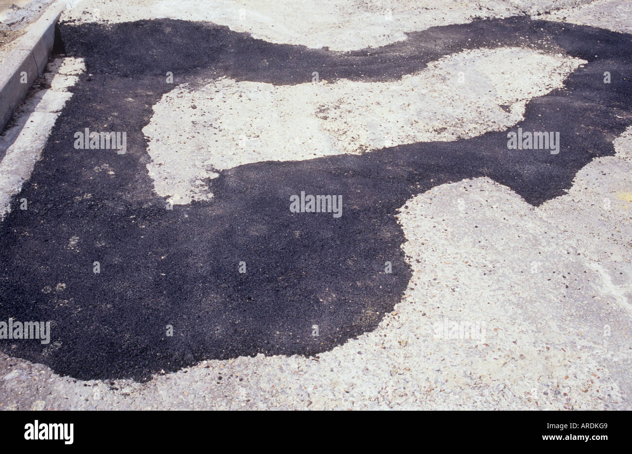 Detail von einem kleinen Teil der Asphaltstraße und Kerb, mit neuer schwarzer Asphalt geflickt Stockfoto