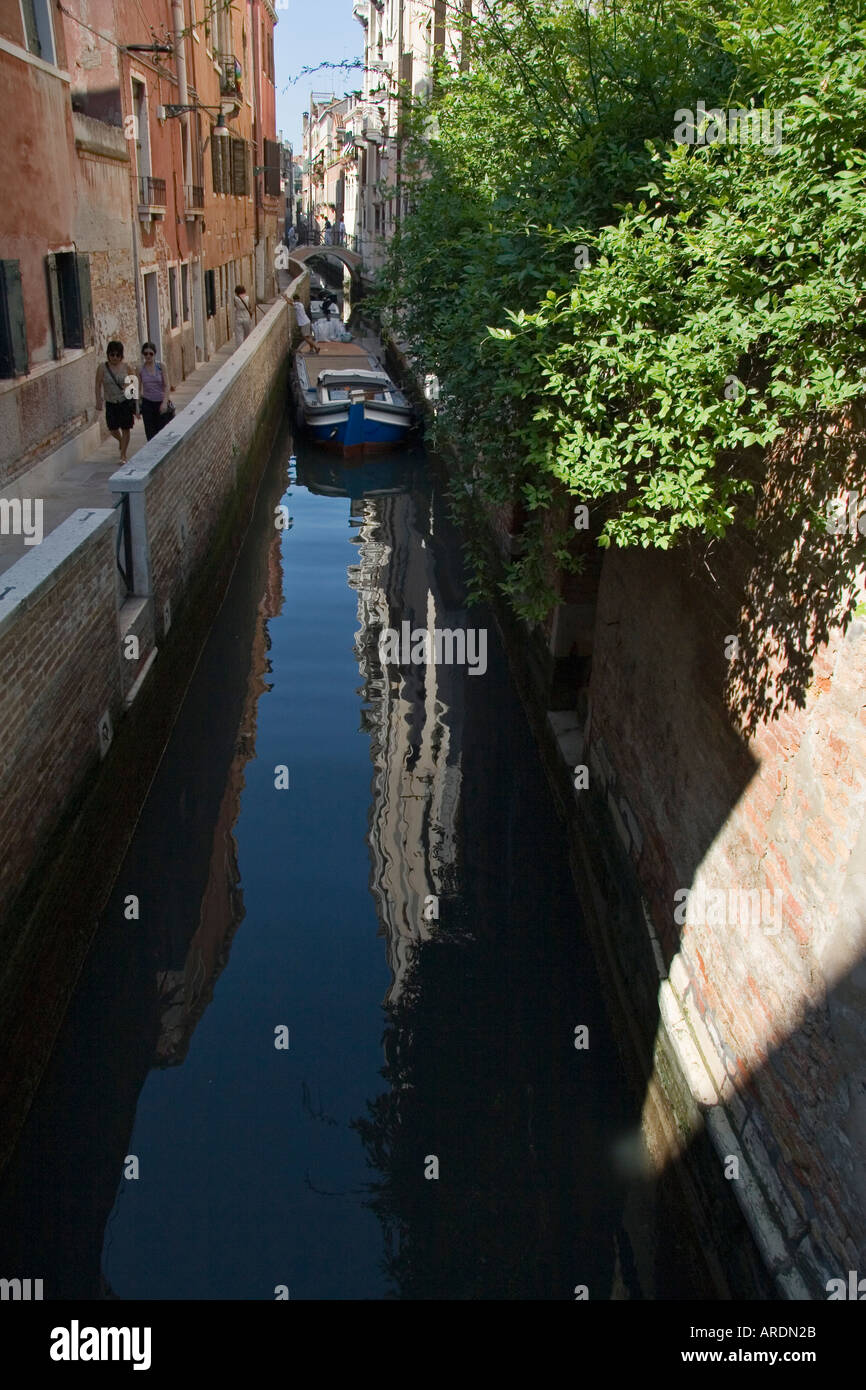 Frauen gehen auf Fußweg neben schmalen Kanal Venedig Italien Stockfoto