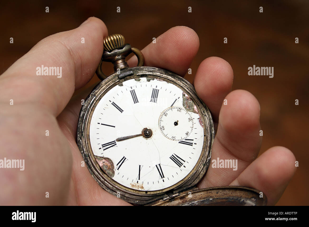 Antike Tasche Uhr in die Hand eines Mannes; isoliert auf orange Stockfoto