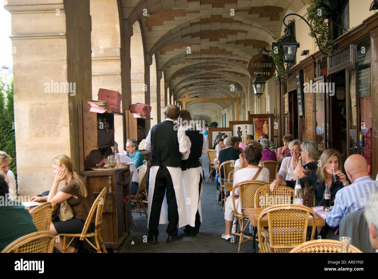 Menschen in einem Café in den Arkaden der Place des Vosges in Le Marais Paris Frankreich Stockfoto