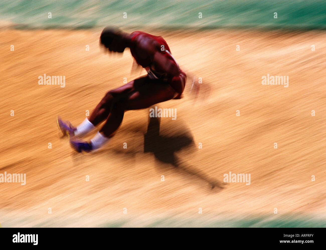 Verschwommene Aktion Bild eines männlichen Athleten tun Weitsprung bei einem Track meet Stockfoto