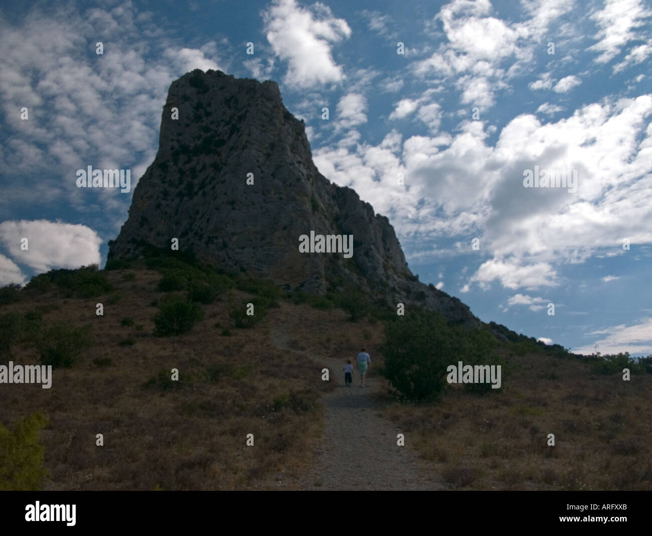 Mutter und Sohn gehen in Richtung einer hohen Felsvorsprung in St Jean de Bueges, Südfrankreich Stockfoto