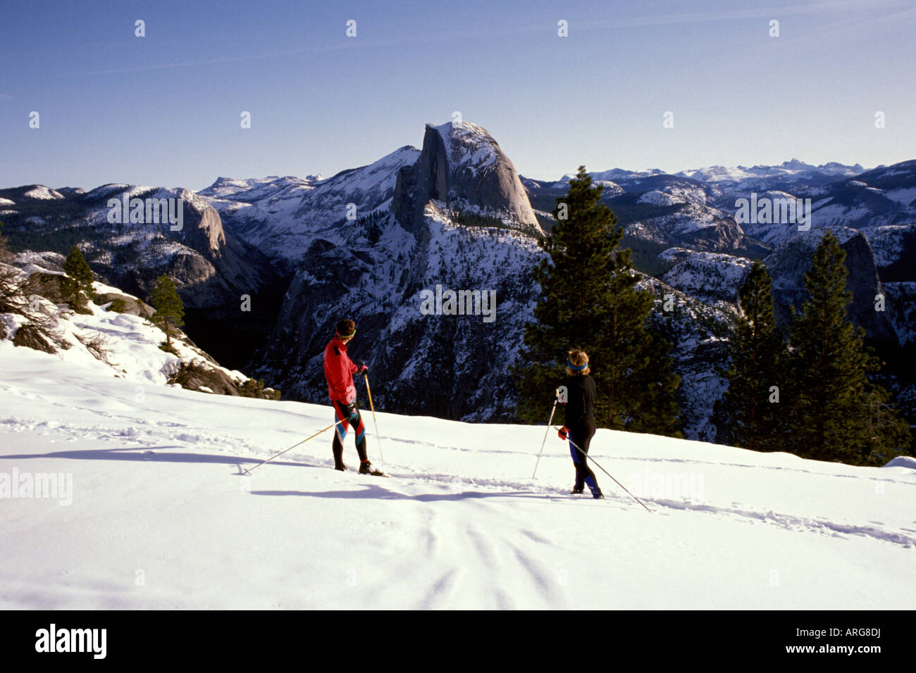 Zwei Langläufer bewundern Half Dome im Yosemite-Nationalpark in Kalifornien in Winter. Stockfoto