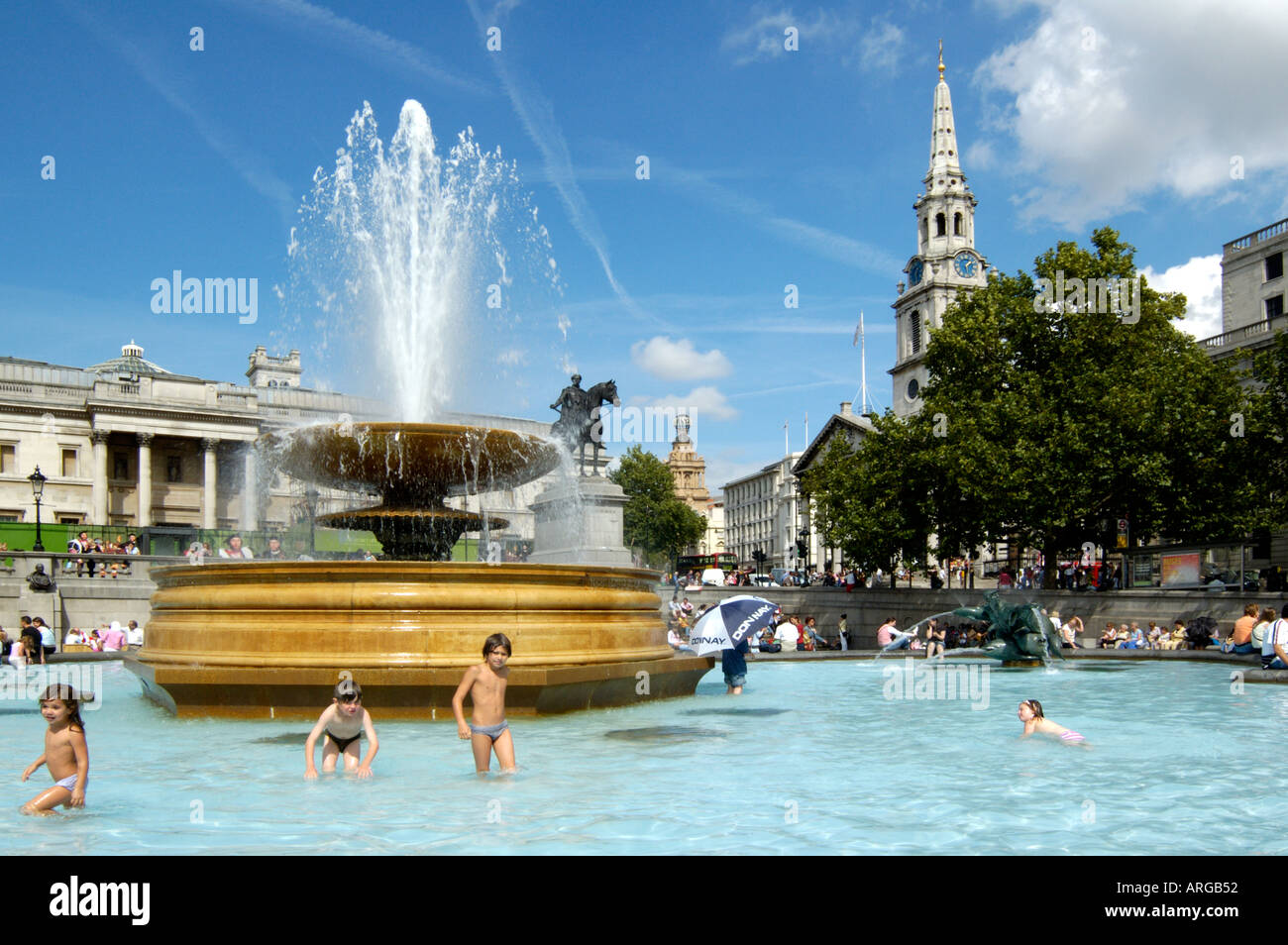 Kinder freuen sich über heißen Sommertag am Trafalgar Square Brunnen Stockfoto