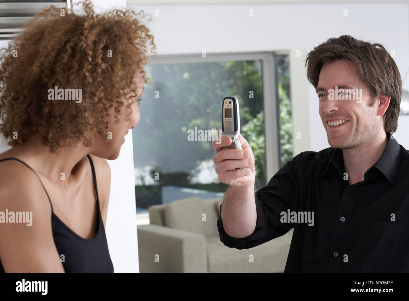 Mann, Bild von Frau mit Kamera-Handy Stockfoto