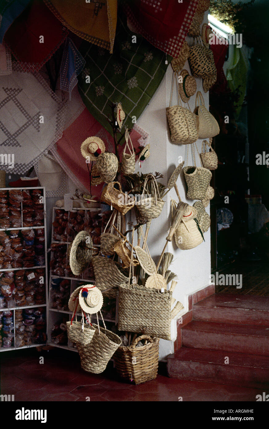 Strohhüte und Körbe hängen an der Wand neben Tischdecken und Espadrilles in den Souvenir-Shop am Museo de Piedras e Artesainia Canaria in der Nähe von Ingenio gestapelt Stockfoto