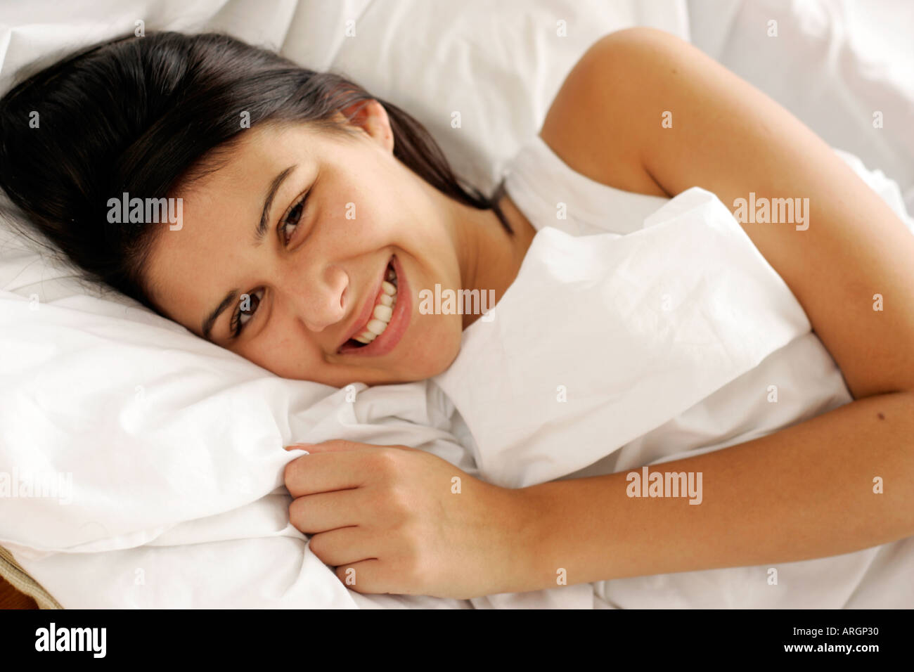 Brünette Mädchen im Bett Stockfoto