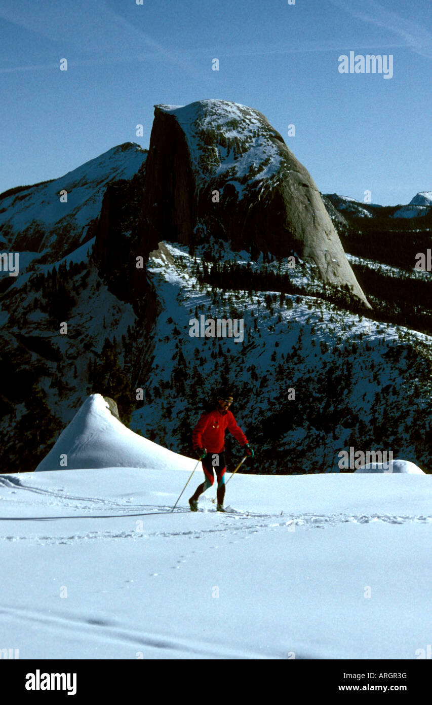Ein Langläufer macht seinen Weg vorbei Half Dome im Yosemite-Nationalpark in Kalifornien. Stockfoto