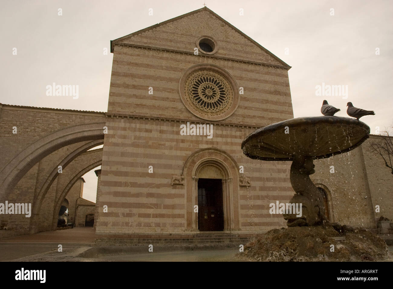 Die Fassade der Heiligen Klara Basilika in Assisi, Umbrien Italien mit den grassierenden Bögen auf der linken Seite Stockfoto