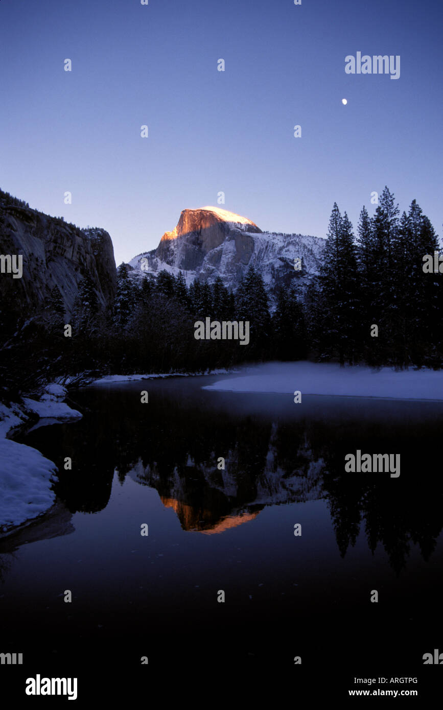 Dawn beginnt zu Half Dome an einem Wintermorgen im Yosemite National Park in Kalifornien Leuchten. Stockfoto