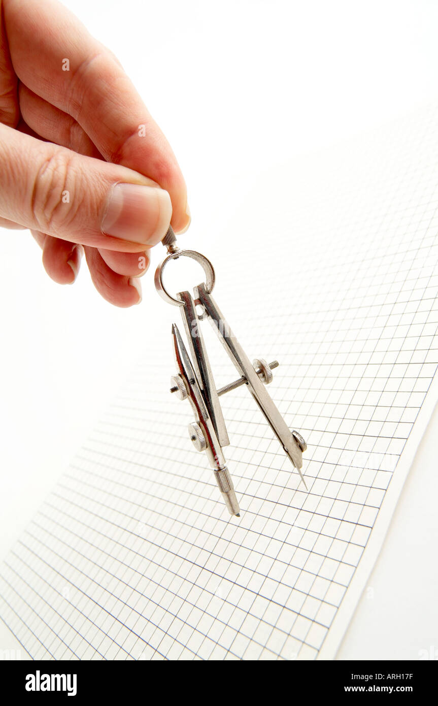Hand mit einem Kompass und Zeichenpapier mit Maßeinteilung Stockfoto